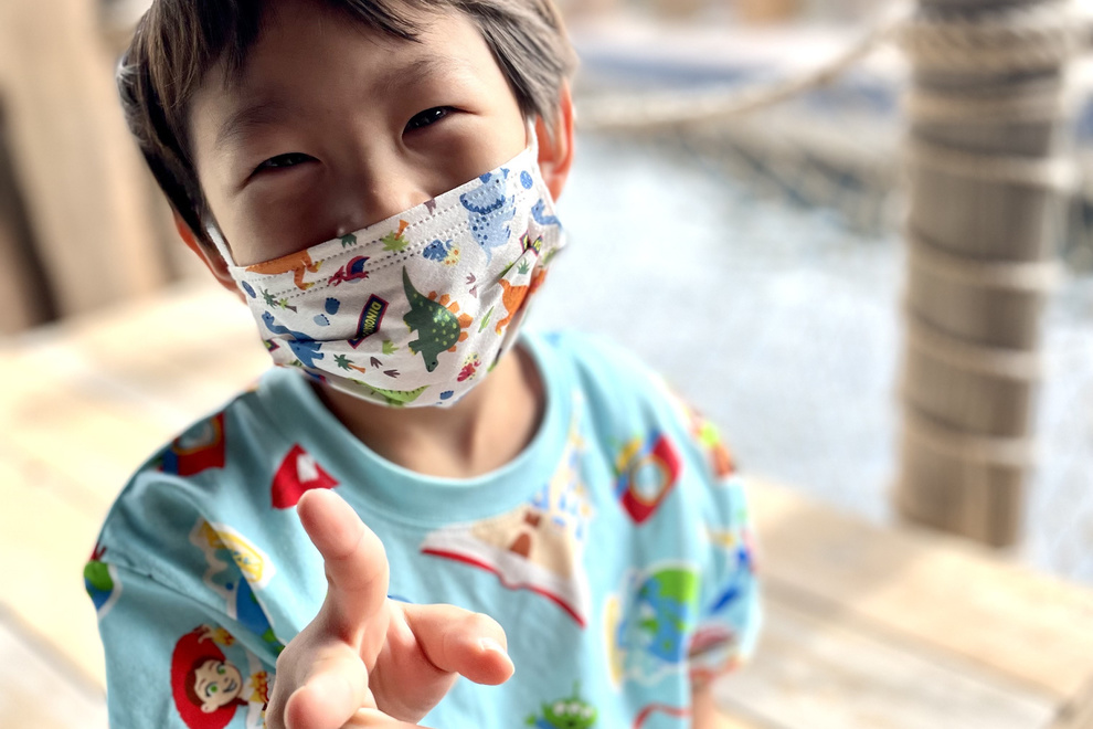 子どもがピースサインをしている写真